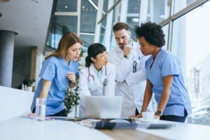 Medical team collaborating around a laptop.
