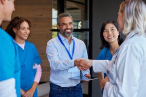 Healthcare professionals shaking hands in meeting.